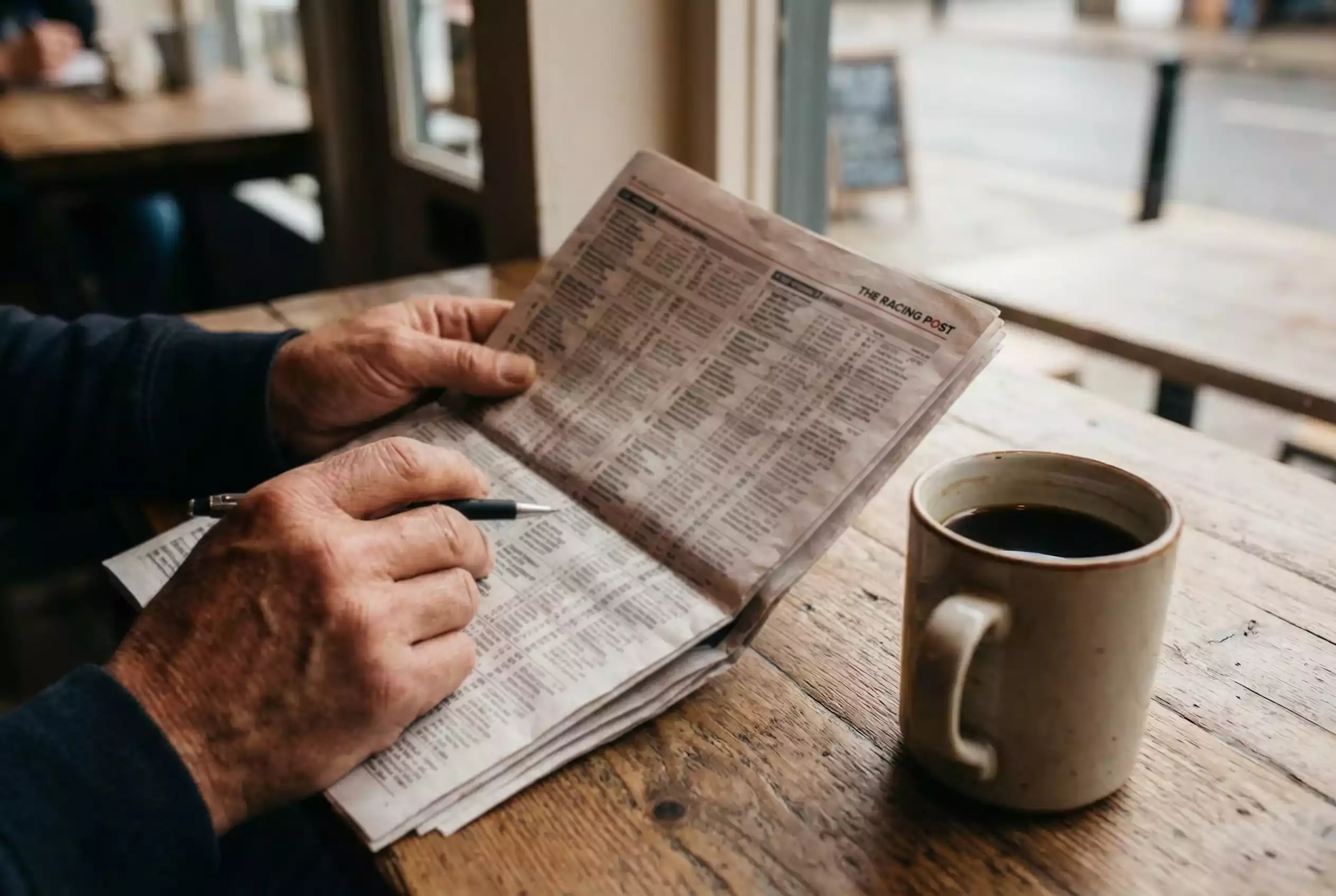 Punter studying racing form and calculating odds on paper
